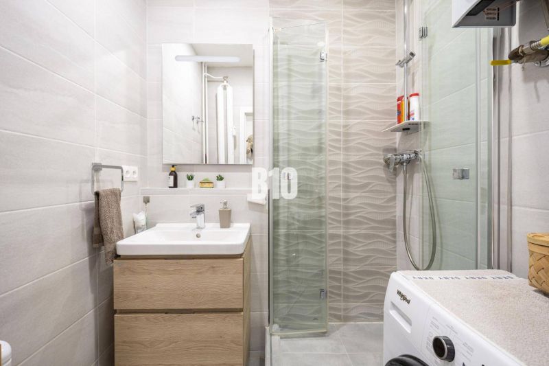 2-izbový byt po rekonštrukcii | Vietnamská ulica, Ružinov | Loggia | B - Kúpeľňa v 2-izbovom byte s práčkou, umývadlom a sprchovým kútom.