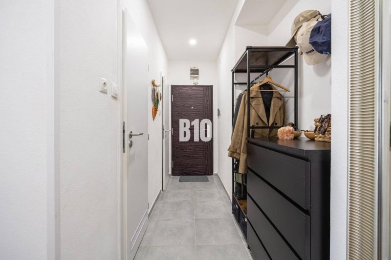 2-izbový byt po rekonštrukcii | Vietnamská ulica, Ružinov | Loggia | B - Predsieň s tmavým nábytkom v 2-izbovom byte s dlaždicovou podlahou.