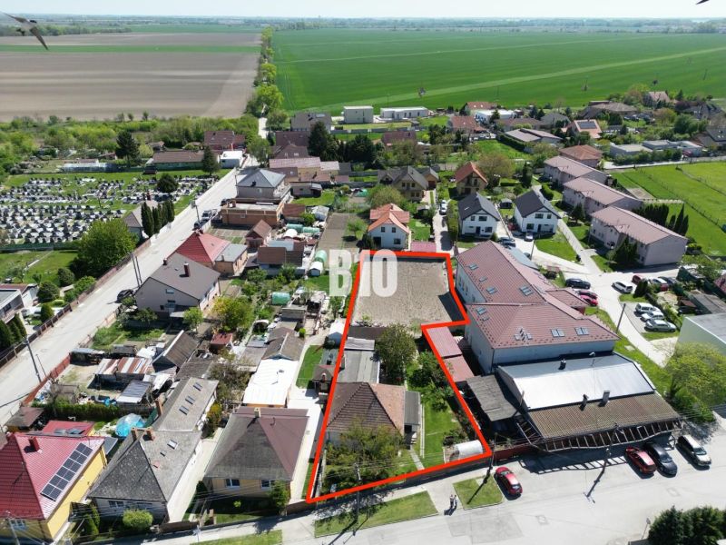 RODINNÉ BÝVANIE S POTENCIÁLOM - KALINKOVO ul.Pekná - Letecký pohľad na rodinné domy v Kalinkove, s pozemkom vyznačeným červenou čiarou.