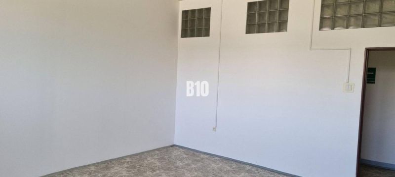 Prenájom obchodných a kancelárskych priestorov - Biela stena so sklenými tvárnicami, podlaha s dreveným dekorom, obchodné priestory.
