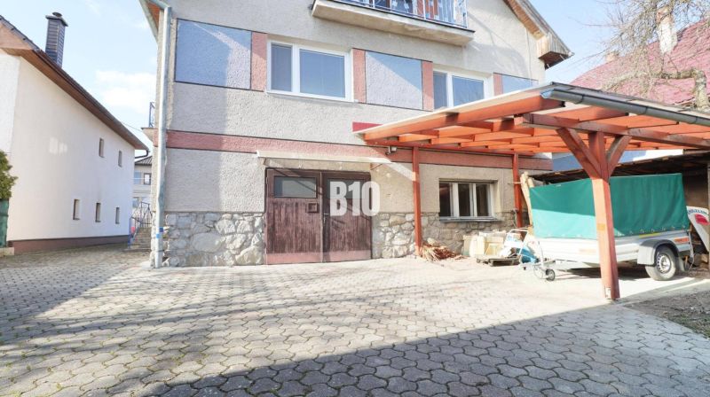 Veľký rodinný dom Turany - Rodinný dom v Turanoch s dreveným prístreškom a príjazdovou cestou.