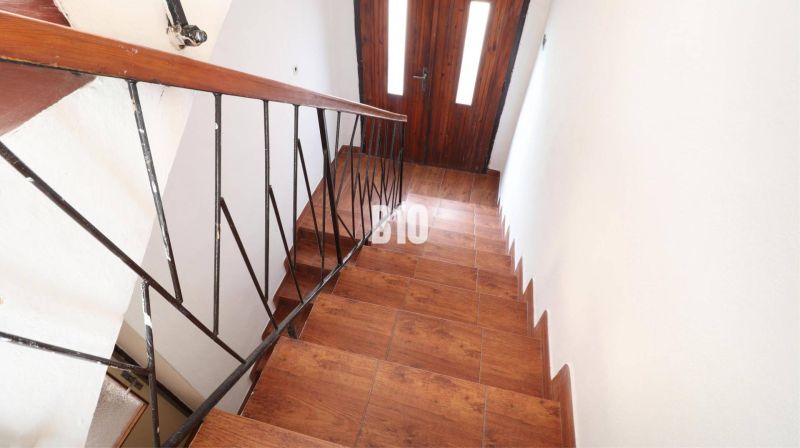 Veľký rodinný dom Turany - Schody s podlahou s dreveným dekorom a kovovým zábradlím v Rodinnom dome.