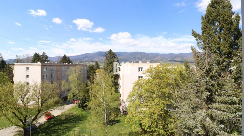 3 izbový byt SEVER, výborná ulica - Pohľad na panelové bytovky v Martine, obklopené zeleňou a horami v pozadí.