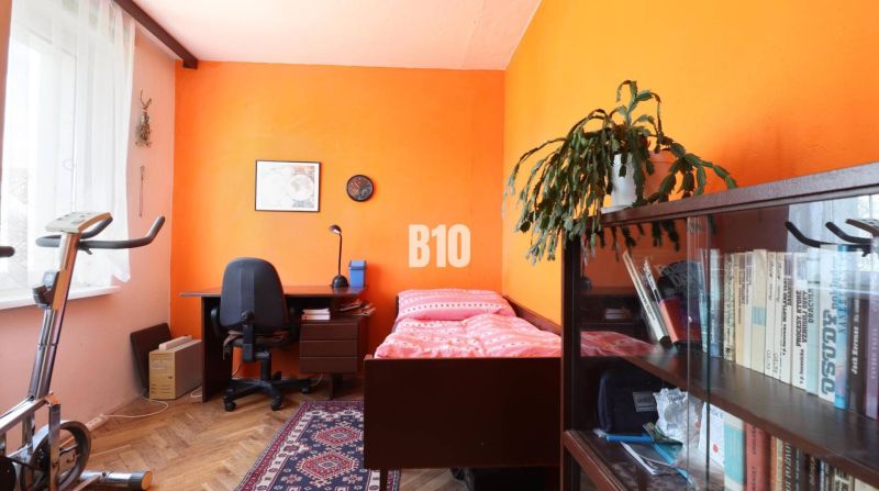3 izbový byt SEVER, výborná ulica - Izba v 3-izbovom byte so zariadením: posteľ, stôl, polica a rotoped.