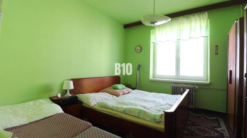 3 izbový byt SEVER, výborná ulica - Zelená spálňa s dvomi posteľami a nábytkom v 3-izbovom byte.