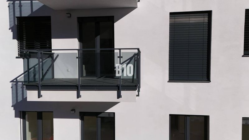 REZERVOVANÝ 2-IZBOVÝ BYT  V NOVOSTAVBE REZIDENCIA KUBÍN! - Balkón s preskleným zábradlím a okenicami na budove dvojizbového bytu v Dolnom Kubíne.