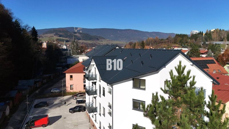 Na predaj byty rôznych veľkostí v bytovom dome REZINDENCIA KUBÍN - Novostavba bytovky v Dolnom Kubíne, s výhľadom na hory a parkoviskom.