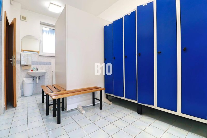 Výrobné a skladové priestory na prenájom Košťany nad Turcom - Šatňa vo výrobných priestoroch s modrými skrinkami a zrkadlom nad umývadlom.