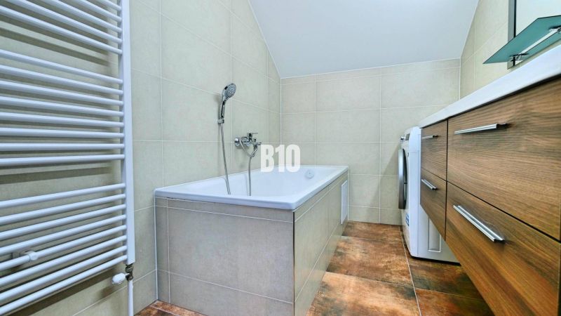 Zrekonštruovaný MEZONET aj so zariadením na výbornej adrese - Košťany  - Kúpeľňa so sprchou, skrinkami a podlahou s dreveným dekorom v 3-izbovom byte.