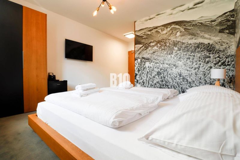 VKUSNE ZARIADENÝ apartmán v TOP lokalite v lyž. stredisku SNOWLAND Val - Interiér Rekreačného apartmánu s pohodlnou posteľou, dekoratívnou stenou a televízorom.