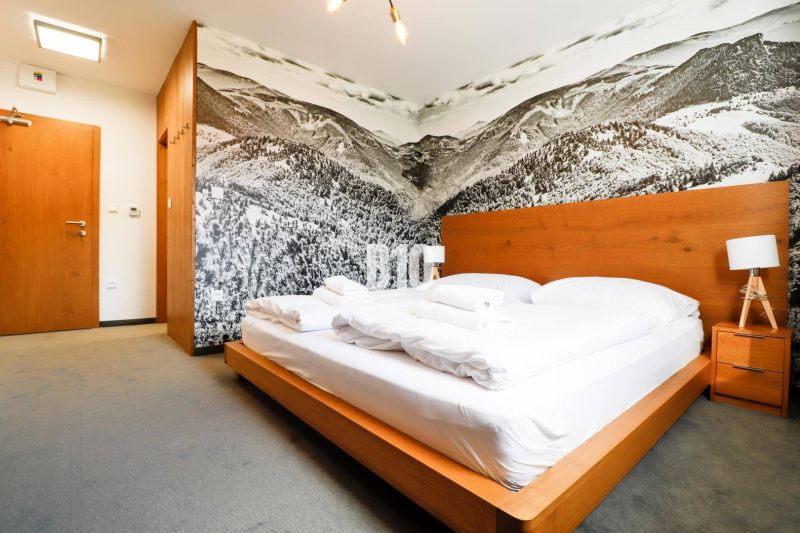 VKUSNE ZARIADENÝ apartmán v TOP lokalite v lyž. stredisku SNOWLAND Val - Spálňa s dreveným nábytkom, veľkým umením na stene a pohodlnou posteľou v Rekreačnom apartmáne.