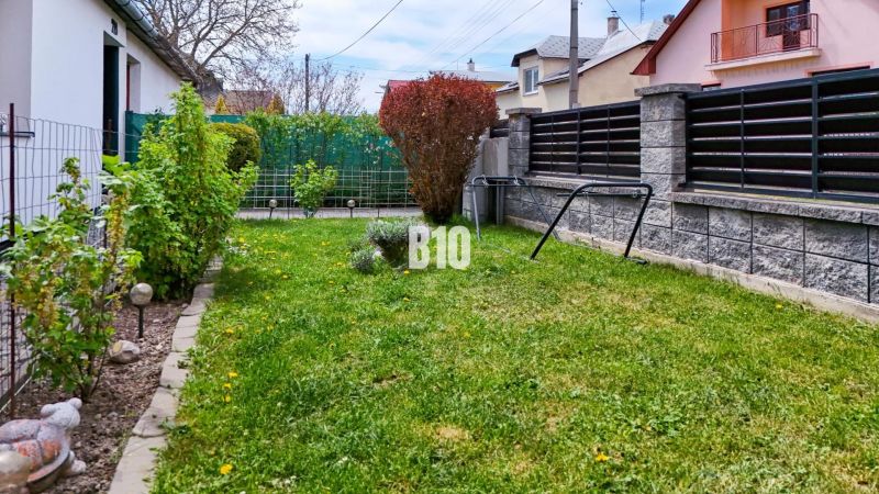 Ideálne bývanie: Zariadený dom 85m² s nízkymi nákladmi - Záhrada pri rodinnom dome v Košťanoch nad Turcom, trávnik, ploty a zeleň.