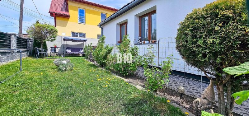 Ideálne bývanie: Zariadený dom 85m² s nízkymi nákladmi - Záhradný priestor pri rodinnom dome v Košťanoch nad Turcom s hojdačkou a sedením.