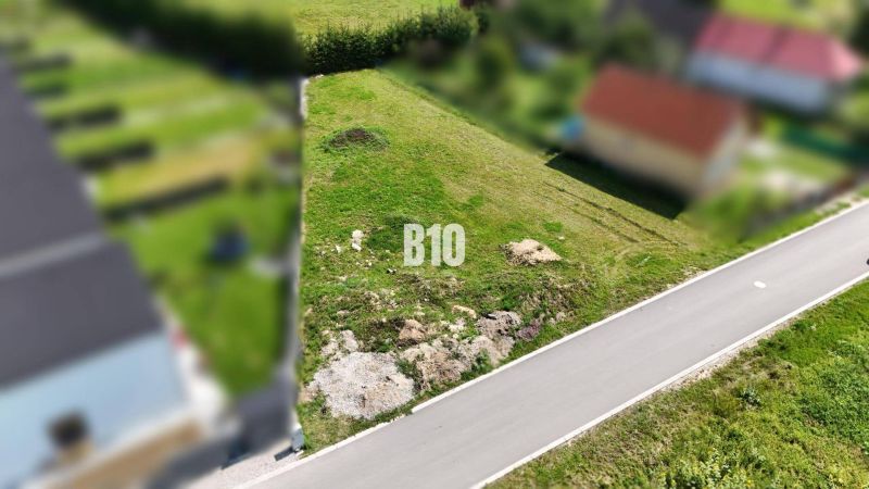 Stavebný pozemok v obci Diaková - Pozemky na bývanie v Diakovej, zelená plocha pri asfaltovej ceste.