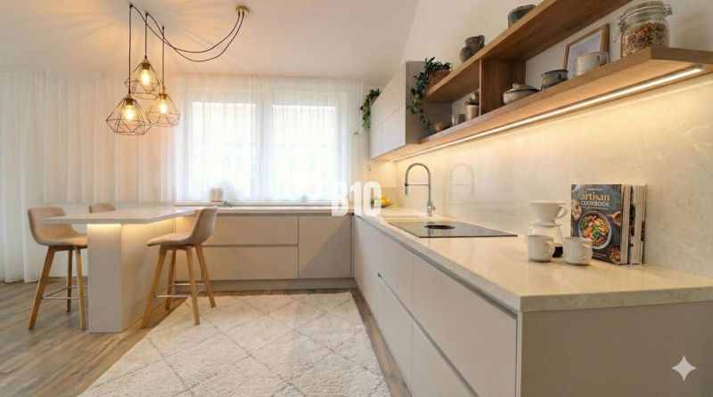Moderná Novostavba: 4-izbový nízkoenergetický dom v obci Diaková - Kuchyňa v rodinnom dome s barovými stoličkami, zaujímavými svetlami a podlahou s dreveným dekorom.