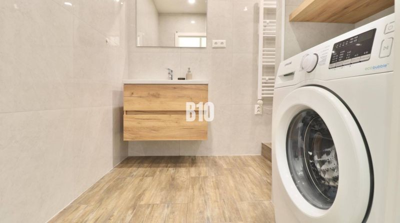 KRÁĽOVSKÝCH 82 m²: Kompletne zrekonštruovaný 3-izbový byt v centre Mar - Kúpeľňa v 3-izbovom byte s práčkou a podlahou s dreveným dekorom.