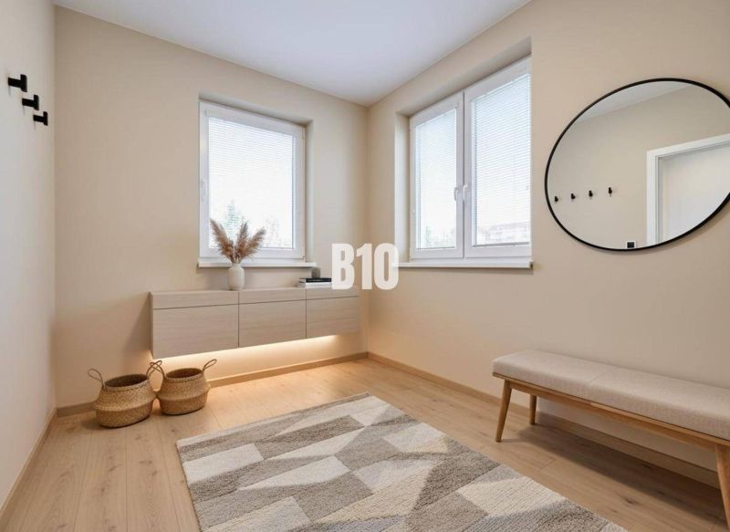 Rodinný dom s rovinatým 10a pozemkom - Interiér rodinného domu s lavicou, okrúhlym zrkadlom a podlahou s dreveným dekorom.
