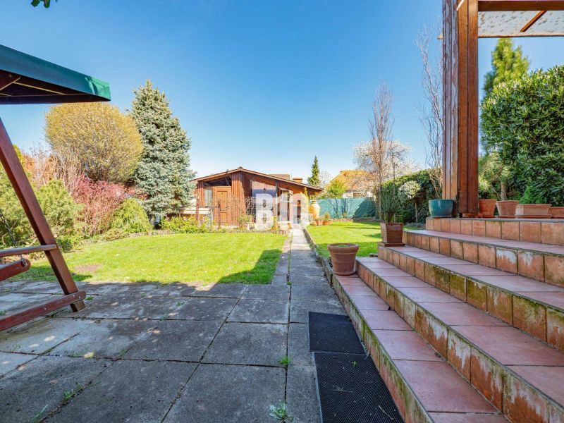 Prerobený 6i rodinný dom, krb a krásna záhrada, TOP lokalita, Zlaté Mo - V záhrade rodinného domu v Zlatých Moravciach sú schody, trávnik a drevený altánok.