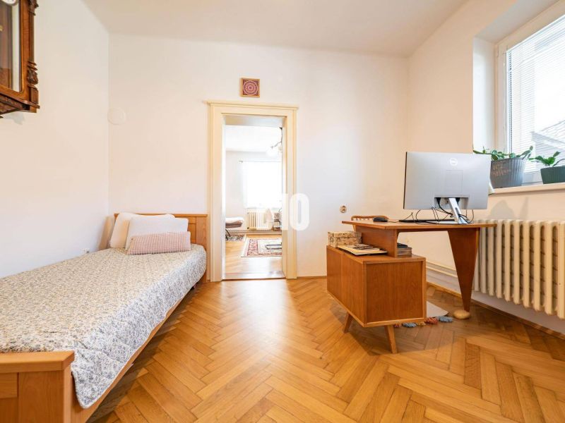 Prerobený 6i rodinný dom, krb a krásna záhrada, TOP lokalita, Zlaté Mo - Izba v rodinnom dome so stolom, posteľou a podlahou s dreveným dekorom.