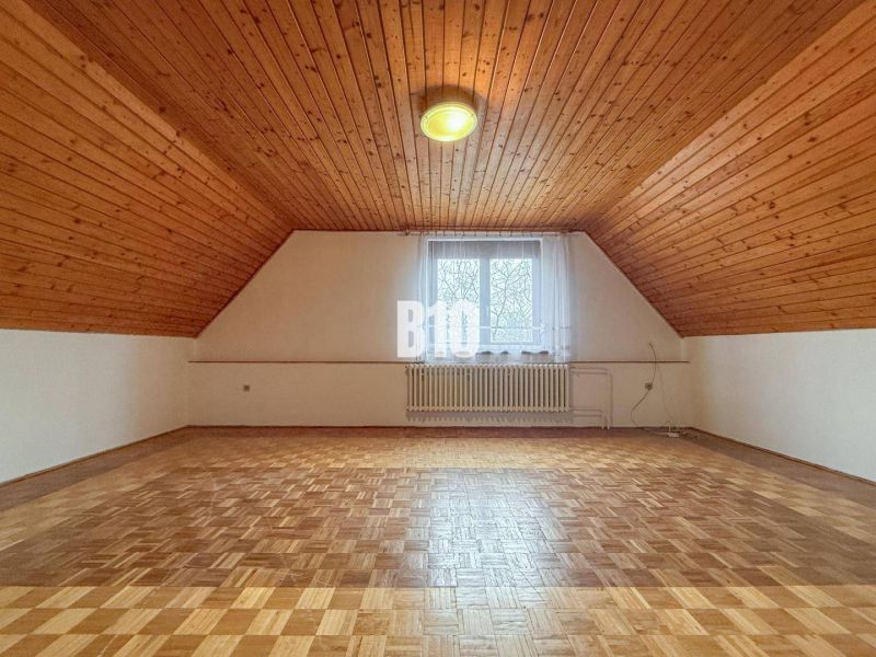 Priestranný rodinný dom s garážou na veľkom pozemku v obci Vlkas - Podkrovná izba v rodinnom dome s dreveným stropom a podlahou s dreveným dekorom.
