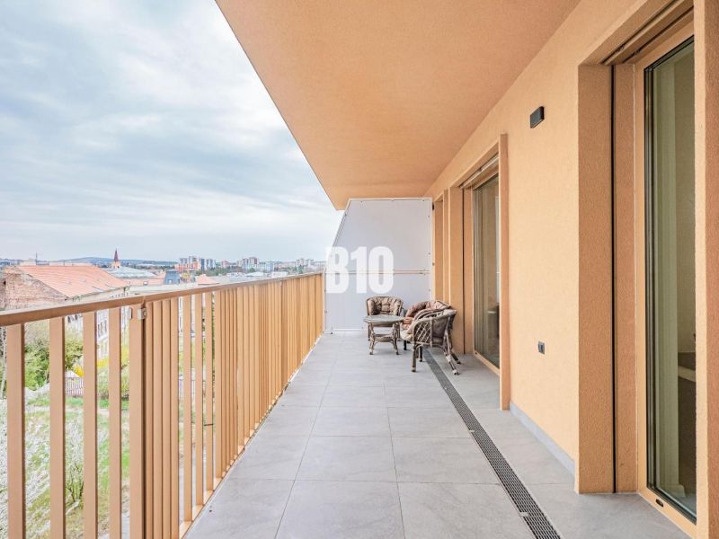 Výnimočný byt s panoramatickým výhľadom na Zobor - Balkón 3-izbového bytu v Nitre s výhľadom na mesto a vonkajším posedením.