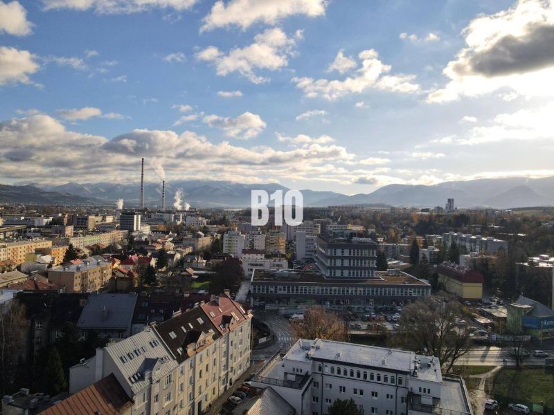 Sad na Studničkách - 2 izbový byt 60m2 - Mesto Žilina s panorámou, bytové domy a priemyselná zóna v popredí.