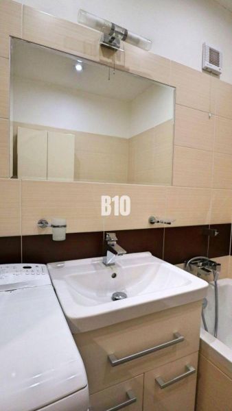 Priestranný 4 izbový byt - Solinky - Kúpeľňa v 4-izbovom byte s umývadlom, zrkadlom a práčkou.