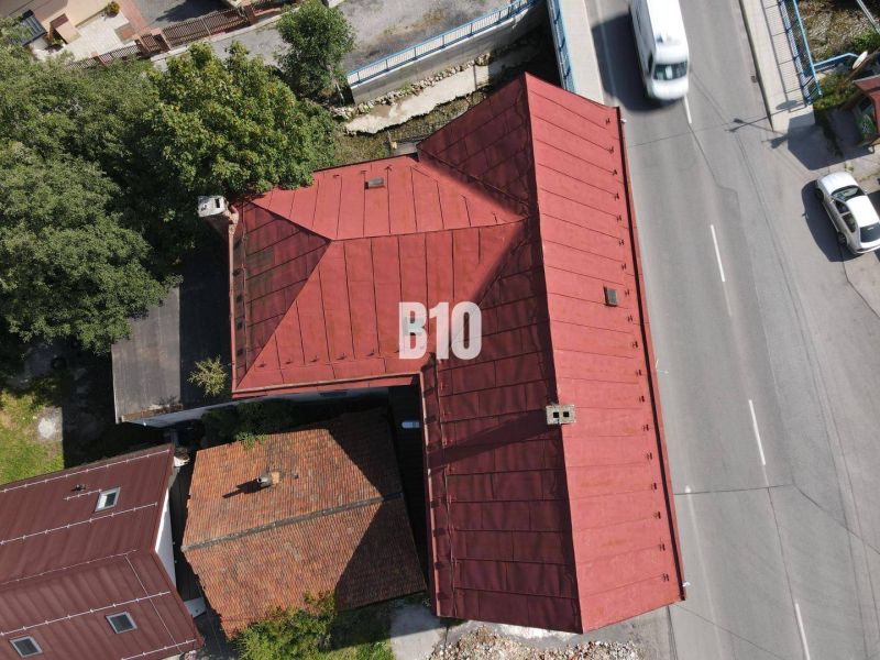 Teraz zľava 30.000 TOP INVESTIČNÁ PRÍLEŽITOSŤ Polyfunkčný objekt na pr - Strecha budovy v Belej a cesta s autami z vtáčej perspektívy.
