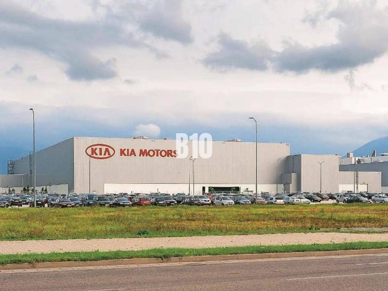 V  PRIAMEJ BLÍZKOSTI KIA  11000m2 lukratívny pozemok na výstavbu - Budova Kia Motors v Žiline, pozemky - komerčné so zaparkovanými autami a trávnatou plochou.