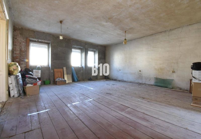 Rodinný dom na rekonštrukciu, 660m2 pozemok. - Priestranná miestnosť v Rodinnom dome s drevenou podlahou a nedokončenými stenami.