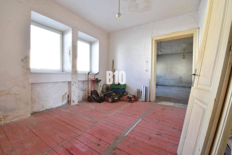 Rodinný dom na rekonštrukciu, 660m2 pozemok. - Izba v rodinnom dome s červenou podlahou a oknami, Bytča.