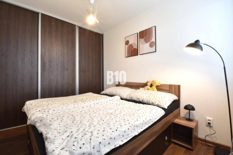 3-izbový byt s parkovaním vo dvore - Spálňa v 3-izbovom byte so vstavanou skriňou a posteľou s dreveným dekorom.