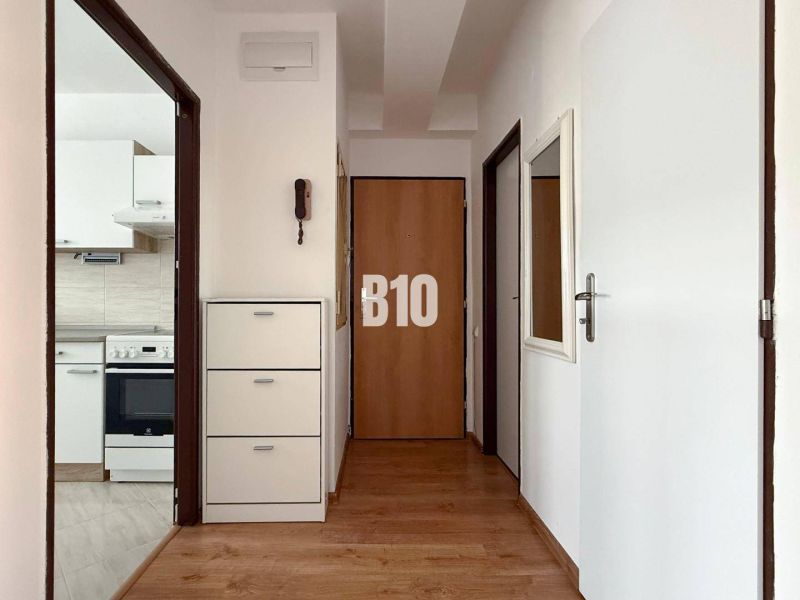 ZNÍŽENÁ CENA 3 izbový MEZONET v obľúbenej lokalite sídliska Juh | Tren - Chodba s podlahou s dreveným dekorom v Rekreačnom apartmáne, v pozadí kuchyňa.