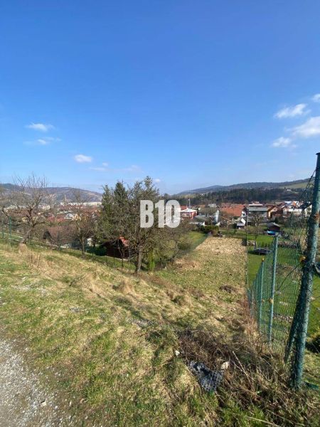 Slnečná záhrada v obci Radoľa na predaj - Trávnatý pozemok v Radoľa s výhľadom na okolie a domy, ideálny pre bývanie.