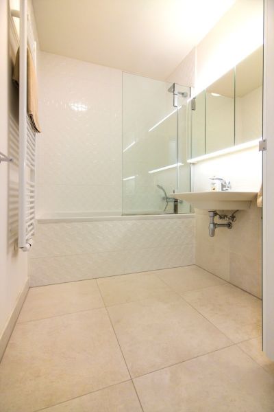 PANORAMA CITY - 2-izbový byt s výhľadom na hrad  - Kúpeľňa s vaňou, umývadlom a veľkými, svetlými dlaždicami v 2-izbovom byte.