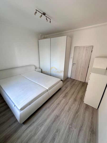 Prenájom moderný 2,5 izbový byt, Šalviová ulica, Bratislava II.Ružinov - Spálňa v 3-izbovom byte s podlahou s dreveným dekorom a bielym nábytkom.