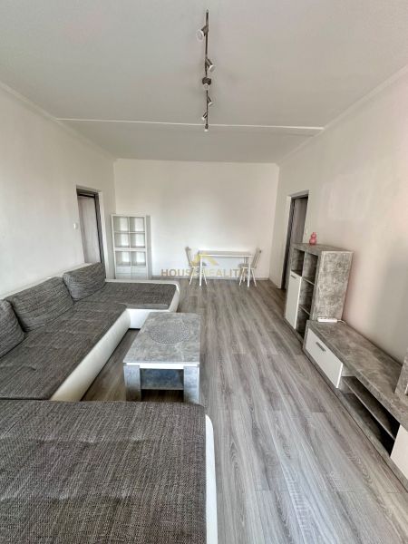 Prenájom moderný 2,5 izbový byt, Šalviová ulica, Bratislava II.Ružinov - Obývacia izba s podlahou s dreveným dekorom a šedou sedacou súpravou v 3-izbovom byte.