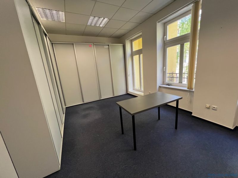 PRENÁJOM dvojkancelárie v centre Starého Mesta, Grösslingová ulica - Kancelárie s kobercom, bielymi stenami a stolom, veľké okná.