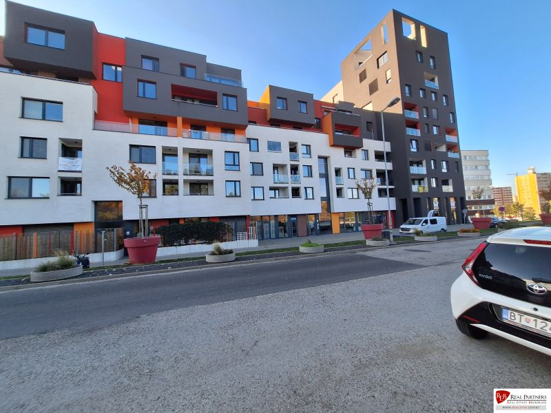 Ponúka na prenájom garsónku v komplexe Čerešne, Polianky Bratis - Bytová budova na Poliankach v Bratislave - Dúbravka s farebnou fasádou a parkoviskom.