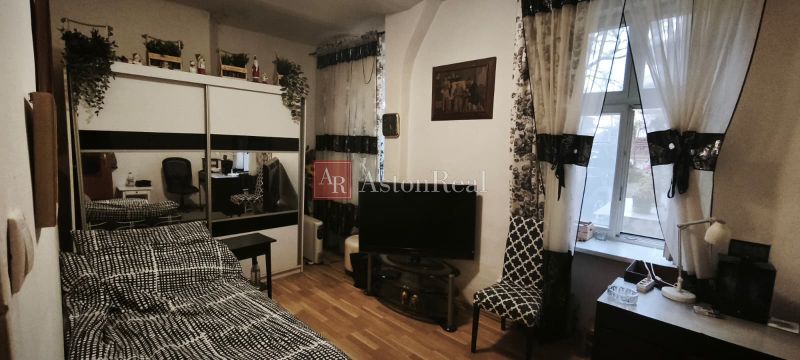 VEĽKORYSÝ 2i byt s rozlohou 76 m² v atraktívnej lokalite- Staré mesto - Izba v 2-izbovom byte s podlahou s dreveným dekorom, televíziou a veľkým zrkadlom.