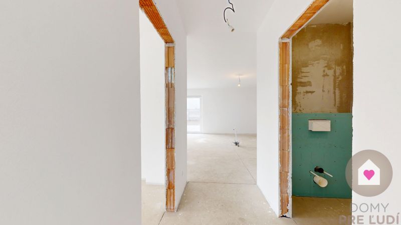 DUNAJSKÁ STREDA- 4i moderná novostavba RD s tep. čerpadlom + garážou - Vo výstavbe rodinného domu je svetlá miestnosť s omietnutými stenami a betónovou podlahou.