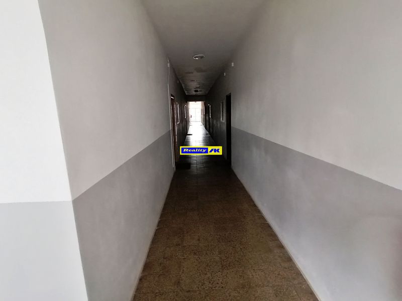 1 izbový byt na predaj rekonštrukcia, Martin centrum, nový balkón - Dlhá chodba s bielymi stenami a dlaždicovou podlahou v 1-izbovom byte.