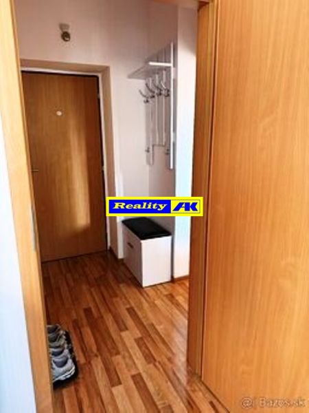 1 izbový byt na predaj rekonštrukcia, Martin centrum, nový balkón - Chodba v 1-izbovom byte s podlahou s dreveným dekorom a vešiakom.