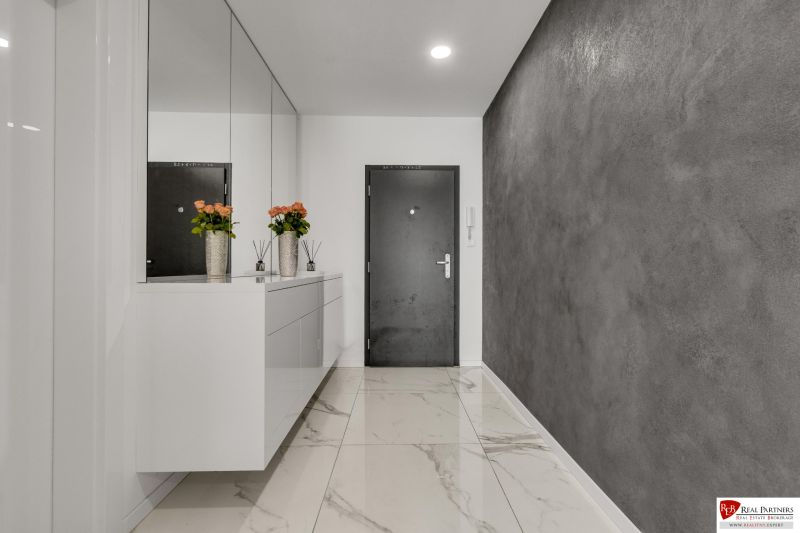 Na predaj nádherný 4 izbový luxusný byt,176 m2 + terasy 55 m2,2 garáž. - Chodba v 4-izbovom byte s mramorovou podlahou a šedými stenami.