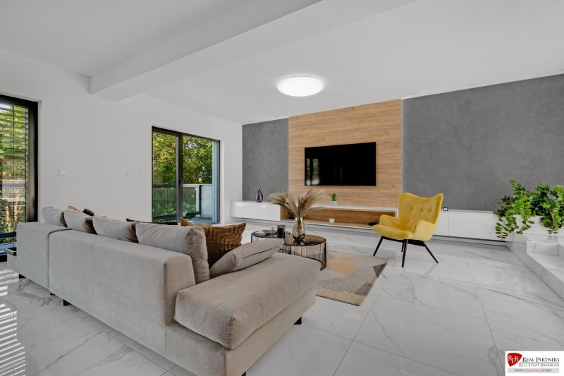 Na predaj nádherný 4 izbový luxusný byt,176 m2 + terasy 55 m2,2 garáž. - Obývacia izba v 4-izbovom byte s gaučom, televízorom a žltým kreslom na mramorovej dlažbe.