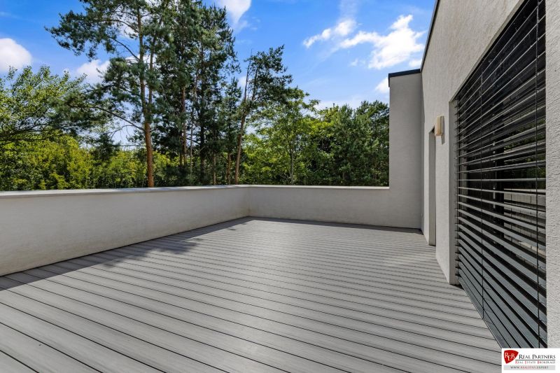 Na predaj nádherný 4 izbový luxusný byt,176 m2 + terasy 55 m2,2 garáž. - Exteriérová terasa 4-izbového bytu na Rekreačnej ulici v Piešťanoch s podlahou s dreveným dekorom.