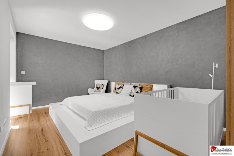 Na predaj nádherný 4 izbový luxusný byt,176 m2 + terasy 55 m2,2 garáž. - Spálňa v 4-izbovom byte s podlahou s dreveným dekorom a šedou stenou.