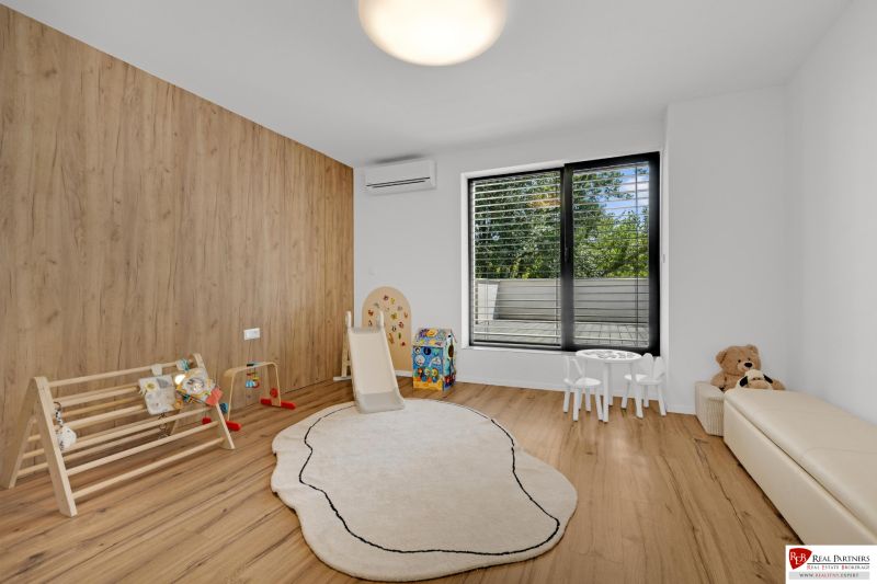 Na predaj nádherný 4 izbový luxusný byt,176 m2 + terasy 55 m2,2 garáž. - Detská izba v 4-izbovom byte s podlahou s dreveným dekorom, hernými prvkami a veľkým oknom.