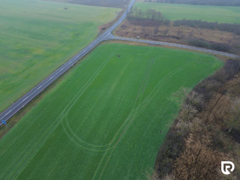 Priemyselné pozemky | 5722 m² + Bonus 2464  | Malacky - Záhorská Ves: Pozemky - komerčné pri cestnej križovatke, zelené pole a zeleň.