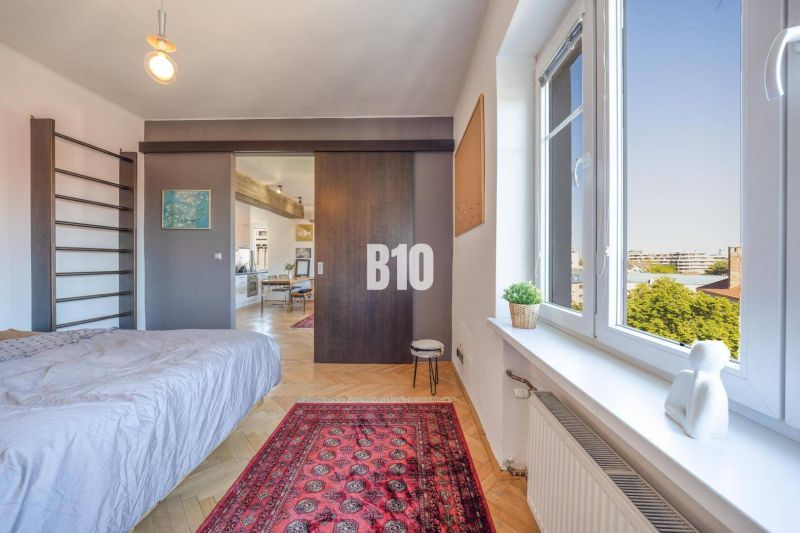 Prenájom | 2-izbový byt | Záhradnícka – Poľská ulica | 900 € + 200 € e - Spálňa v 2-izbovom byte s kobercom a podlahou s dreveným dekorom.